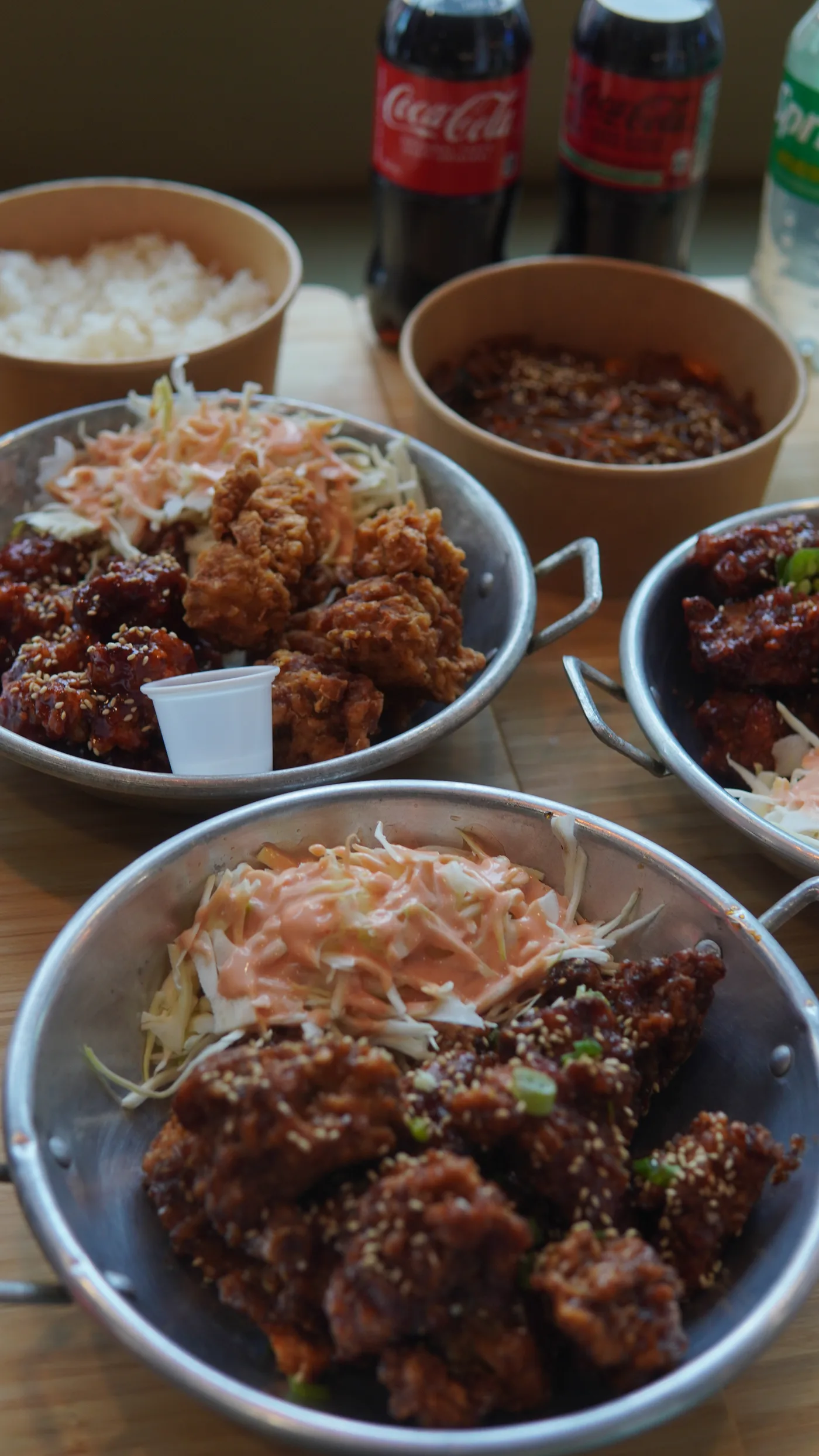 Pans of glazed fried chicken and coleslaw on a buffet table